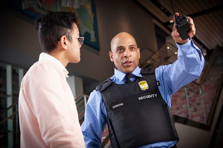 Retail or condo security guard helping customer with directions